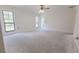Spacious bedroom with neutral walls, two windows and ceiling fan with lighting at 12196 Ne 4Th Pl, Oxford, FL 34484