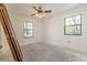 A bright bedroom featuring dual windows and a ceiling fan with a vintage style lighting fixture at 12196 Ne 4Th Pl, Oxford, FL 34484