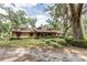 Well-maintained brick home with a landscaped front yard and mature trees, offering a warm and inviting curb appeal at 12196 Ne 4Th Pl, Oxford, FL 34484