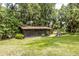 Exterior view of a screened building surrounded by lush green grass and trees at 12196 Ne 4Th Pl, Oxford, FL 34484