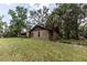 Brick home with lush green lawn and landscaping, offering a serene and private setting at 12196 Ne 4Th Pl, Oxford, FL 34484