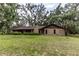 Well-maintained brick home with a spacious front yard, surrounded by mature trees and landscaping at 12196 Ne 4Th Pl, Oxford, FL 34484