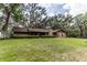 Brick home with a lush front lawn and mature trees, set in a peaceful, secluded location at 12196 Ne 4Th Pl, Oxford, FL 34484