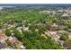 Expansive aerial view showing the neighborhood, mature trees, and nearby lake at 1254 Magnolia Farms Ct, Eustis, FL 32726