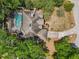 Aerial view of the property showcasing the home, screened pool, and surrounding mature trees at 1254 Magnolia Farms Ct, Eustis, FL 32726