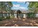 View of the backyard featuring a gate leading to a screened-in pool area and surrounding lush greenery at 1254 Magnolia Farms Ct, Eustis, FL 32726