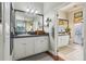 Bright bathroom with white cabinets, granite counters, and a large framed mirror over the vanity at 1254 Magnolia Farms Ct, Eustis, FL 32726