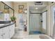 The bathroom features white tile flooring, a shower with glass doors, and a framed window at 1254 Magnolia Farms Ct, Eustis, FL 32726