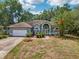 Charming single-story home with a well-maintained lawn and a beautiful palm tree in the front yard at 1254 Magnolia Farms Ct, Eustis, FL 32726