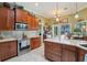 Well-equipped kitchen with stainless steel appliances, wooden cabinets, and an island at 1254 Magnolia Farms Ct, Eustis, FL 32726