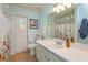 Bright bathroom featuring a floral shower curtain and white vanity at 12846 Brown Bark Trl, Clermont, FL 34711