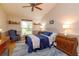 Cozy bedroom featuring ceiling fan, wainscoting and plush blue carpet at 12846 Brown Bark Trl, Clermont, FL 34711