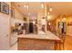 Bright eat-in kitchen features granite countertops, stainless steel appliances, and a stone-accented breakfast bar at 12846 Brown Bark Trl, Clermont, FL 34711