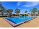 Sparkling community pool surrounded by palm trees and lounge chairs with a covered pavilion at 12846 Brown Bark Trl, Clermont, FL 34711