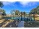 Outdoor tennis court with a black chain link fence and visible court rules signage at 12846 Brown Bark Trl, Clermont, FL 34711