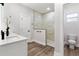 Bright bathroom with marble-tiled shower, modern fixtures, and wood-look flooring at 13524 Sw 89 St, Dunnellon, FL 34432