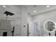 Modern bathroom featuring a tiled shower with a rainfall showerhead, a vanity with a backlit mirror, and neutral wall colors at 13524 Sw 89 St, Dunnellon, FL 34432