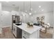 Kitchen with a view into the living room, featuring white cabinets and stainless steel appliances at 13524 Sw 89 St, Dunnellon, FL 34432