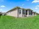 The backyard shows a well-maintained lawn, with an exterior view of the home with white trimming at 14235 Se 85Th Ave, Summerfield, FL 34491