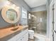 Stylish bathroom with a glass enclosed shower, decorative mirror, and vanity with storage at 14235 Se 85Th Ave, Summerfield, FL 34491