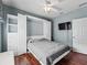 Modern bedroom with a murphy bed, hardwood floors, and a mounted television at 14235 Se 85Th Ave, Summerfield, FL 34491