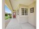 Inviting covered front porch featuring decorative windows, front door, and rock landscaping at 14235 Se 85Th Ave, Summerfield, FL 34491