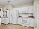 Bright kitchen featuring white appliances, plenty of cabinet space, and tile flooring at 14235 Se 85Th Ave, Summerfield, FL 34491