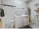 Bright laundry room featuring updated washer and dryer, ample storage shelves, and hot water tank at 14235 Se 85Th Ave, Summerfield, FL 34491