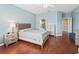 Spacious main bedroom with hardwood floors, tray ceiling, and ensuite bathroom at 14235 Se 85Th Ave, Summerfield, FL 34491