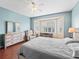 Relaxing main bedroom with a large bay window, hardwood floors, and neutral decor at 14235 Se 85Th Ave, Summerfield, FL 34491