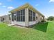 A screened-in lanai at the back of the home is surrounded by a manicured lawn and landscaping at 14235 Se 85Th Ave, Summerfield, FL 34491