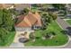 This home is surrounded by lush landscaping, a patterned driveway, and mature trees, offering great curb appeal at 1501 Lavaca Ln, The Villages, FL 32159