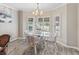 Bright dining area with a glass-top table, comfortable seating, and natural light streaming through shuttered windows at 1501 Lavaca Ln, The Villages, FL 32159