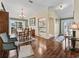 Elegant dining room with hardwood floors, stylish furniture, and natural light, seamlessly connecting to the kitchen at 1501 Lavaca Ln, The Villages, FL 32159