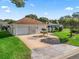 Inviting single story home with a two-car garage, manicured lawn, and decorative driveway at 1501 Lavaca Ln, The Villages, FL 32159
