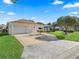 Charming home featuring a well-manicured lawn, mature landscaping, and a convenient two-car garage at 1501 Lavaca Ln, The Villages, FL 32159