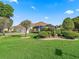 Beautiful single-story home with lush lawn, mature landscaping, and a screened lanai at 1501 Lavaca Ln, The Villages, FL 32159