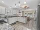 Bright kitchen featuring granite countertops, white cabinetry, and stainless steel appliances, adjacent to a dining area at 1501 Lavaca Ln, The Villages, FL 32159