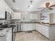 Well-lit kitchen with granite countertops, white cabinets, stainless steel appliances, and a stylish backsplash at 1501 Lavaca Ln, The Villages, FL 32159