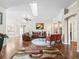 Open-concept living room with hardwood floors, a leather sofa, and views of the kitchen and dining area at 1501 Lavaca Ln, The Villages, FL 32159