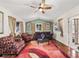 Bright living room with ceiling fan, multiple windows, and a stylish area rug at 1501 Lavaca Ln, The Villages, FL 32159