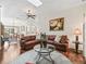Open living room with hardwood floors, a leather sofa, and a view into the dining and kitchen areas at 1501 Lavaca Ln, The Villages, FL 32159