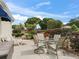 Outdoor patio features a dining table, lounge chair, and lush landscaping at 1501 Lavaca Ln, The Villages, FL 32159