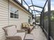 Relaxing sunroom with wicker seating, tile floors, and views of the beautifully landscaped yard at 1501 Lavaca Ln, The Villages, FL 32159