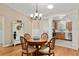 Elegant dining area with wooden table and chairs, decorative accents, and convenient access to the kitchen at 1502 Blueberry Way, The Villages, FL 32162