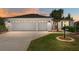 Charming home featuring a two-car garage, well-manicured lawn, and beautiful landscaping at 1502 Blueberry Way, The Villages, FL 32162