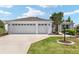 Charming home featuring a two-car garage, well-manicured lawn, and beautiful landscaping at 1502 Blueberry Way, The Villages, FL 32162