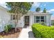 Welcoming home entrance with lush landscaping, decorative details, and a paved walkway at 1502 Blueberry Way, The Villages, FL 32162