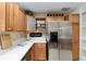 Well-organized kitchen featuring wood cabinets, stainless steel refrigerator, and stylish decor at 1502 Blueberry Way, The Villages, FL 32162