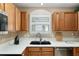 Bright kitchen with black sink, modern faucet, stainless steel dishwasher, and ample countertop space at 1502 Blueberry Way, The Villages, FL 32162